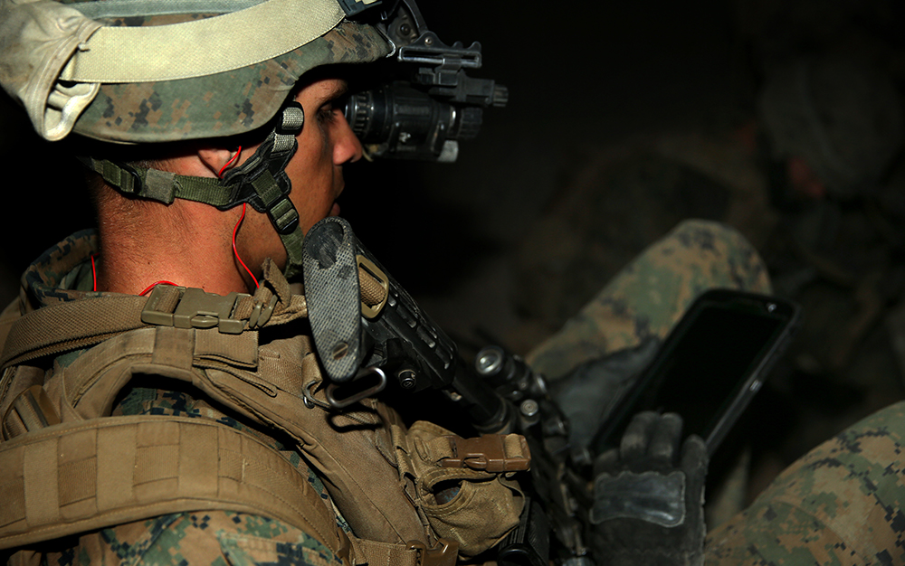 solider looks down at tablet during training exercise in Twentynine Palms, CA