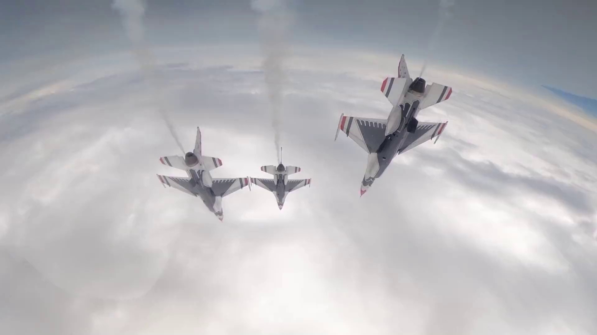 three fighter jets fly in formation over the clouds high in the atmosphere